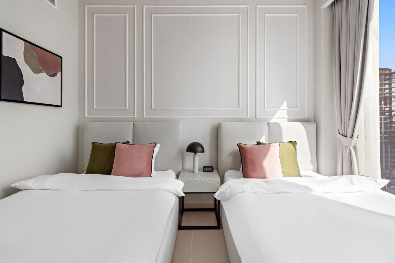 Ein Hotelzimmer mit zwei Betten, einem Nachttisch mit Lampe und einem Bild an der Wand.