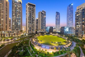 A high-rise residential area with modern architecture, a central green space, and well-lit streets.