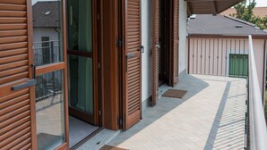 Un balcon doté de portes-fenêtres coulissantes et d’une grille en métal.