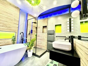 Un bagno moderno con una vasca freestanding, una doccia con pareti in vetro e un mobile lavabo con specchio.