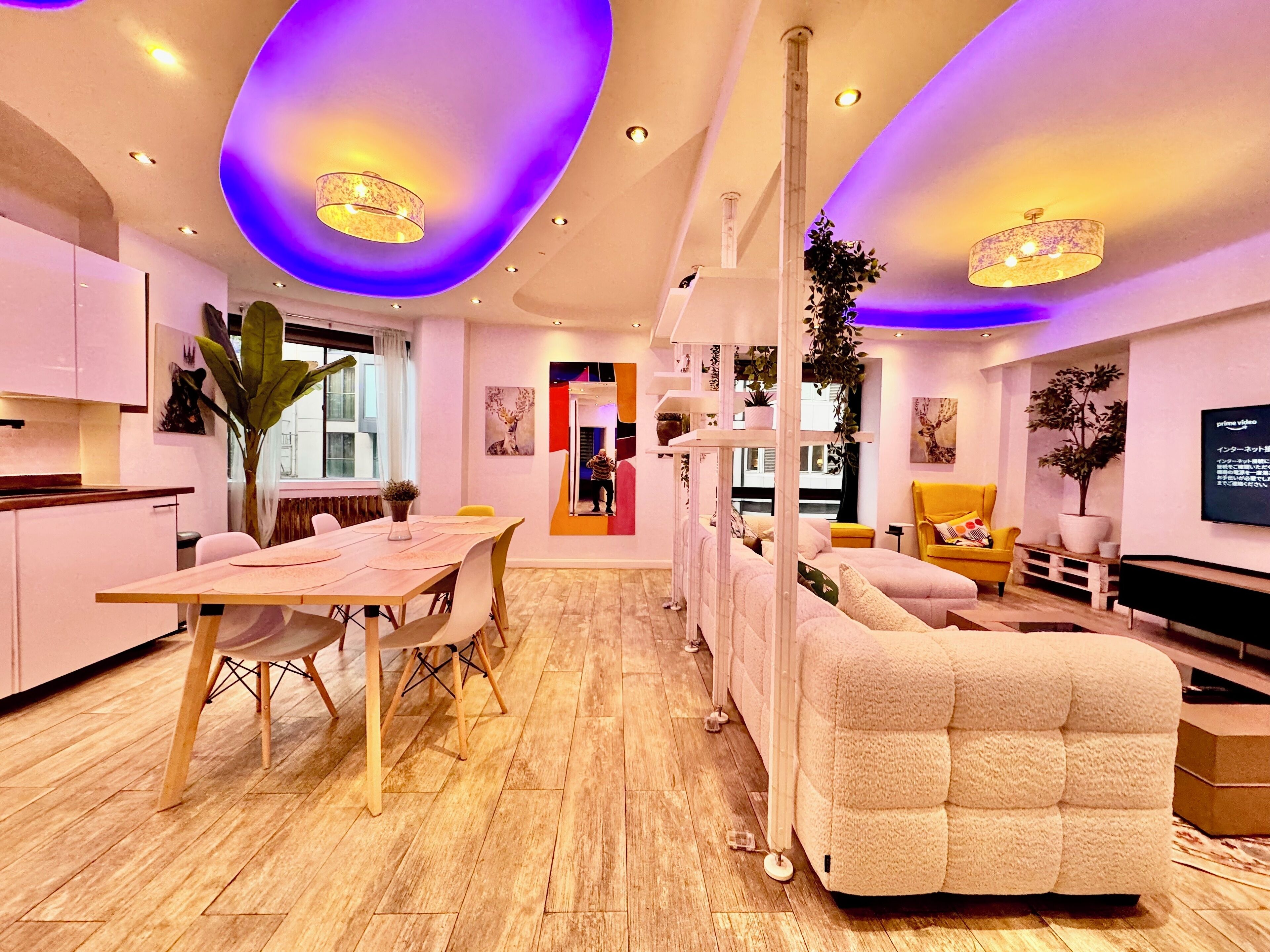 A modern living room with a sofa, a dining table, and a TV.