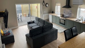 Una cocina moderna con horno empotrado y un comedor con mesa de madera.