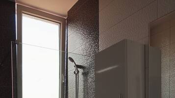 A bathroom with a shower, toilet, and sink.