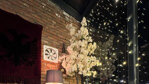 A cozy dining area with a table set for tea, featuring a bowl of tea, a teapot, and a lemon wedge. - Antika Hotel (Pec)