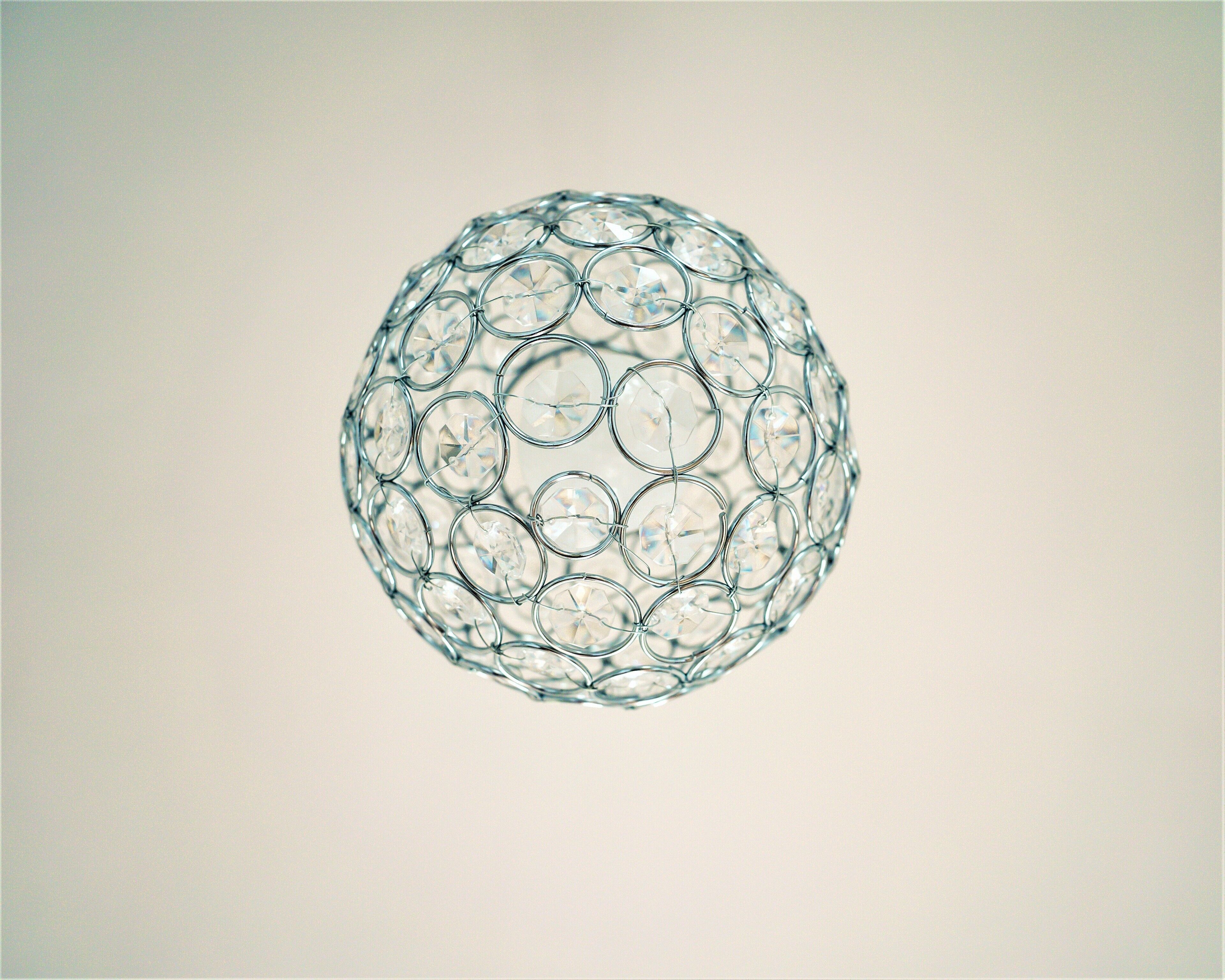 A spherical glass object with a wireframe structure.
