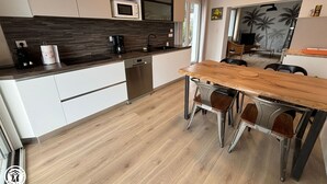A modern kitchen with a wooden countertop, built-in microwave, and stainless steel appliances.