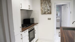 A kitchen with white cabinets, a microwave, a stove, and an oven.