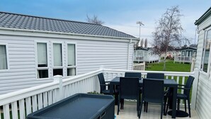 A deck with outdoor furniture and a storage bench. - Place2bee , Caravan , Manor park , Free Wifi ,6 Berth (Hunstanton)