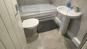 Un baño con bañera, inodoro y lavabo.
