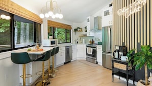 A modern kitchen with a dining area, a large window, and a sign reading "Relax & Play Chalet". - Luxury tree house-like accommodations in the Blue Ridge Mountains. Ski/bike/hike (Mars Hill)