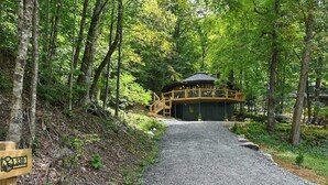 A forested area with a gravel path leading to a wooden cabin with a balcony. - Luxury tree house-like accommodations in the Blue Ridge Mountains. Ski/bike/hike (Mars Hill)