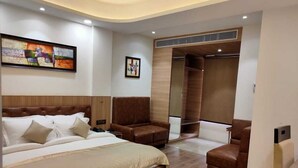 A modern bedroom with a large bed, a seating area, and a walk-in closet. - Jb innovations (Lucknow)