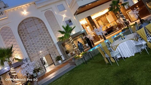 A luxurious villa with a swimming pool, outdoor seating, and a well-lit entrance. - Jb innovations (Lucknow)