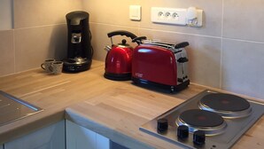 A modern kitchen with a built-in stove, a coffee maker, a kettle, and a toaster. - Contemporary Apartment near ski lift - sleeps4/5 (Saint-Jean-d'Aulps)