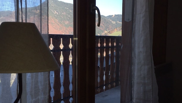 A room with a view of mountains through a window with a decorative railing. - Contemporary Apartment near ski lift - sleeps4/5 (Saint-Jean-d'Aulps)