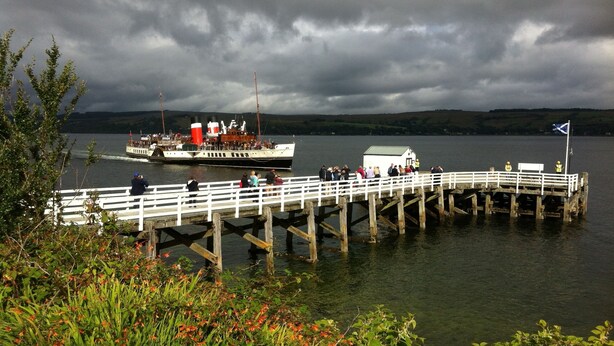 A pier extending into a lake with a boat docked at the end.