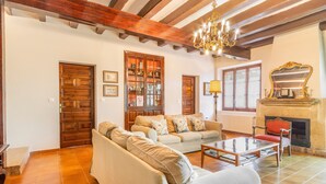 Una sala de estar con sofá, mesa de centro, chimenea y puertas de madera.