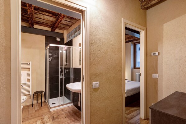 Un baño con ducha, lavabo e inodoro.