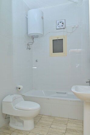 Een badkamer met een toilet, een bad en een wastafel.