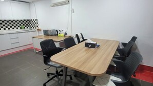 A conference room with a wooden table, black office chairs, and a whiteboard. - Hotel&Stay Heyyum - Juan (Incheon)