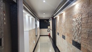 A hallway with a tiled floor, a brick wall on one side, and a door on the other. - Hotel&Stay Heyyum - Juan (Incheon)