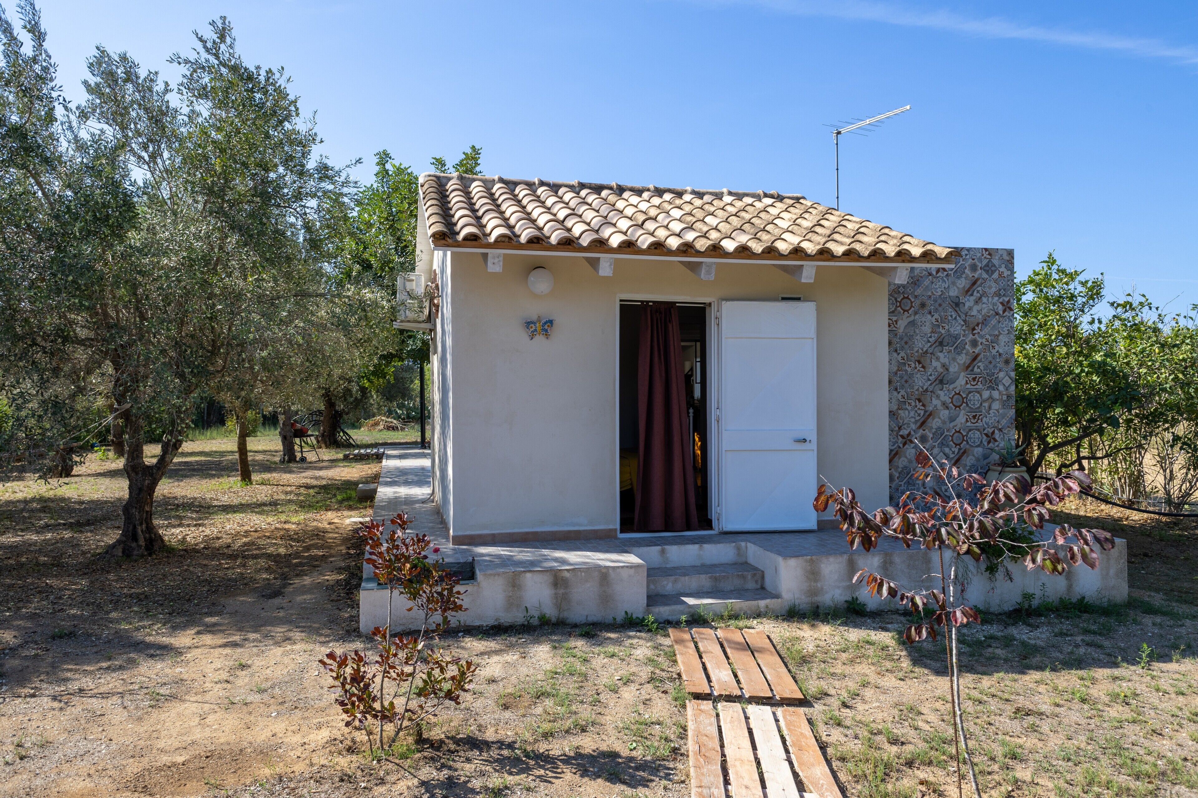 Un petit bâtiment d’un seul étage, doté d’un toit en tuiles, d’une porte et d’un petit porche.