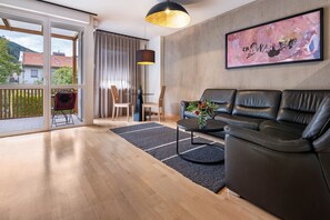 A modern living room with a leather sofa, a coffee table, and a painting on the wall. - Apartment 'Ferienwohnung Hans' with Mountain View, Balcony and Wi-Fi (Prad am Stilfserjoch)