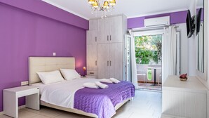 Um quarto com cama, mesas de cabeceira, guarda-roupa, televisão e varanda com vista.