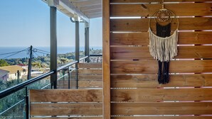 Uma escadaria de madeira com vista para o mar, um sonho pendurado na parede e um corrimão.