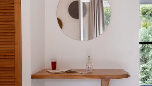A wooden console table with a glass decanter, a book, and a glass of red liquid. - Room 'Deluxe Loft - D' with Shared Terrace, Wi-Fi and Air Conditioning (Parga)