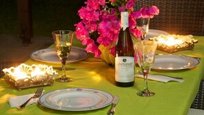 Une table mise pour un repas, avec une bouteille de vin, des verres, des assiettes et un centre de table décoratif.