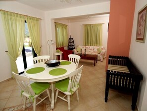 A dining area with a round table, chairs, and a black bench.