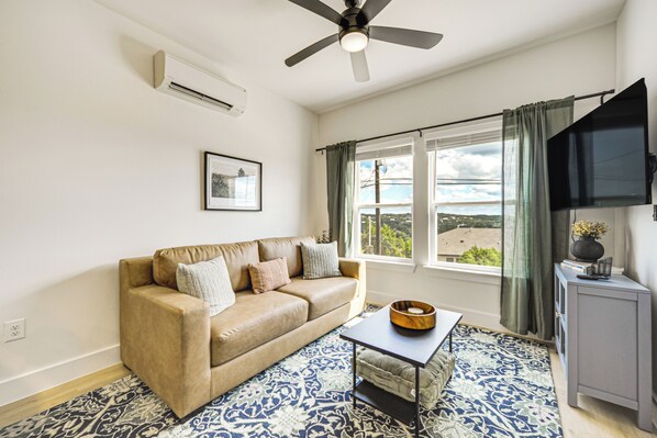 Relax in this inviting living room with a comfortable sofa, flat-screen TV, and stunning views of the surrounding landscape.