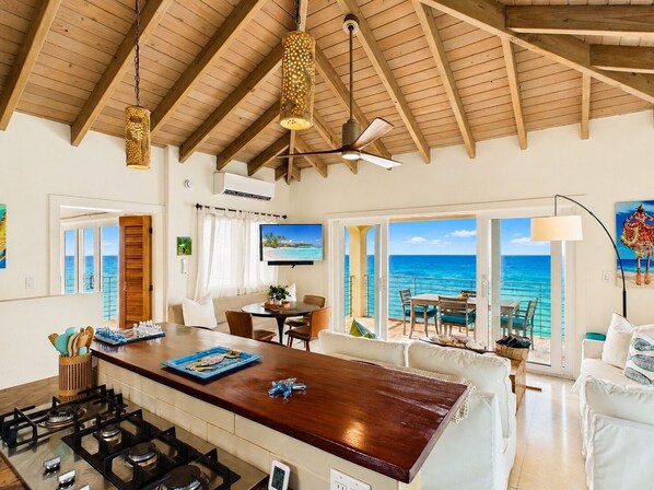 A spacious living area with a wooden ceiling, a kitchen island, and a view of the ocean. - Enjoy amazing sea views, private pool & Caribbean breezes from this 2 bd villa! (La Vallee)