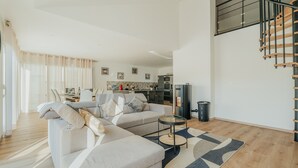 Una sala moderna con sofá, mesa de centro y escalera.