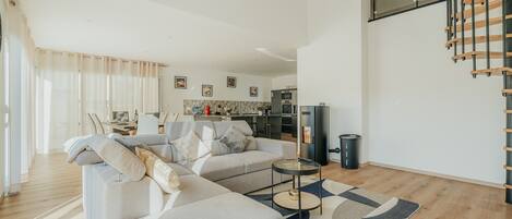A modern living room with a sofa, coffee table, and a staircase.
