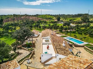 Une villa dotée d’une piscine, d’un toit recouvert de tuiles en terre cuite et offrant une vue sur la campagne environnante.
