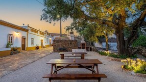A courtyard with stone benches, a stone wall, and a traditional oven. - Holiday Home 'Casa Do Poço - Vale Luís Neto' with Mountain View, Wi-Fi and Air Conditioning (Loulé)