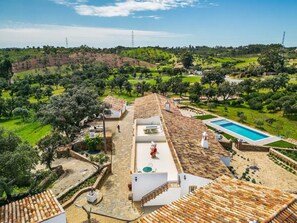 A villa with a swimming pool, terracotta roof, and a view of the surrounding countryside. - Holiday Home 'Casa Do Poço - Vale Luís Neto' with Mountain View, Wi-Fi and Air Conditioning (Loulé)