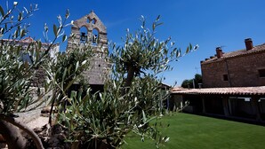 An olive tree, a bell tower, and a building with a tiled roof. - Rural House 'La Casa Vieja De Vizmalo' with Hot Tub, Mountain Views & Garden in Burgos (Vizmalo)