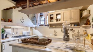 A kitchen with white cabinets, a stove, a sink, and a window with curtains. - Holiday Home 'Greg's House' with Private Pool, Garden and Wi-Fi (Santa Lucia)
