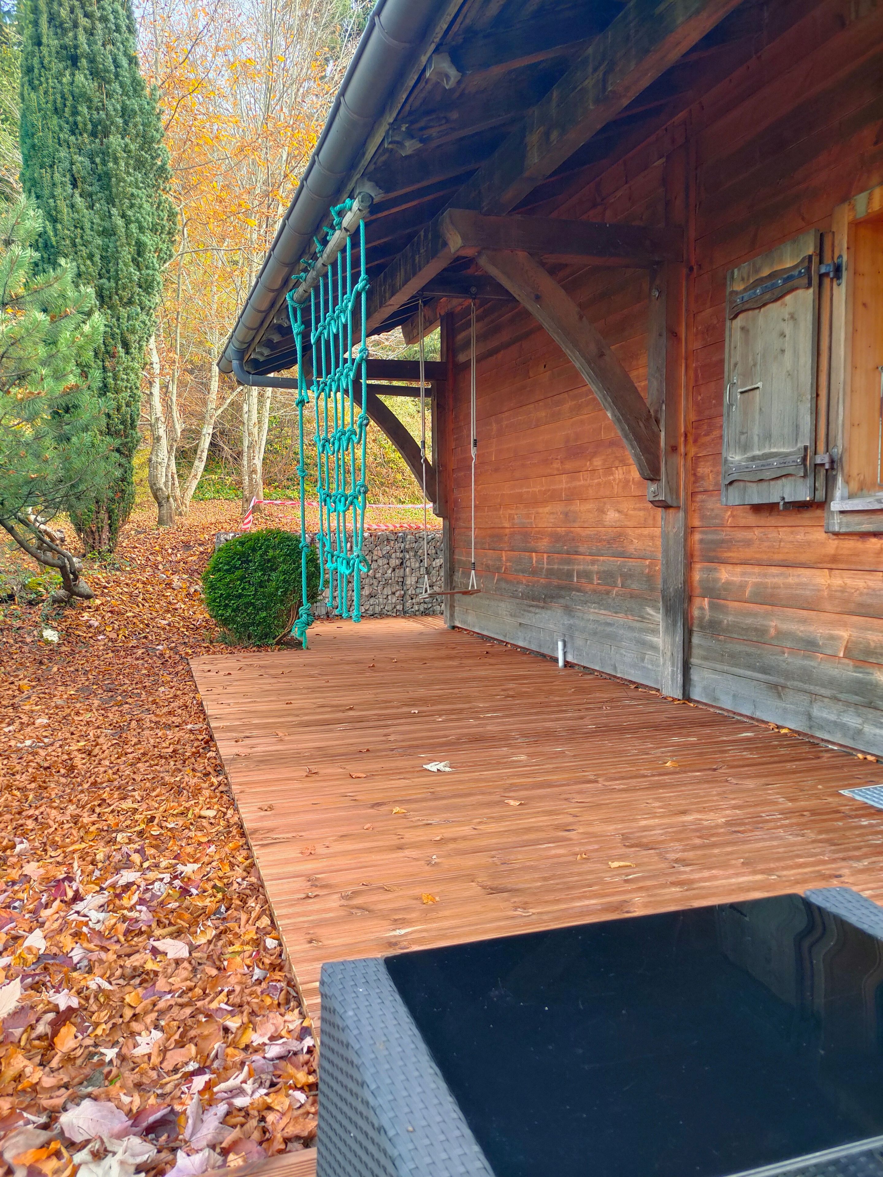 A wooden building with a stone wall and a wooden deck.