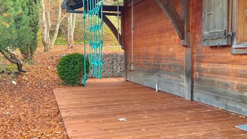 A wooden building with a stone wall and a wooden deck.