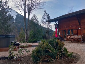 Une cabane en bois dotée d’un espace extérieur aménagé et d’une terrasse en gravier.