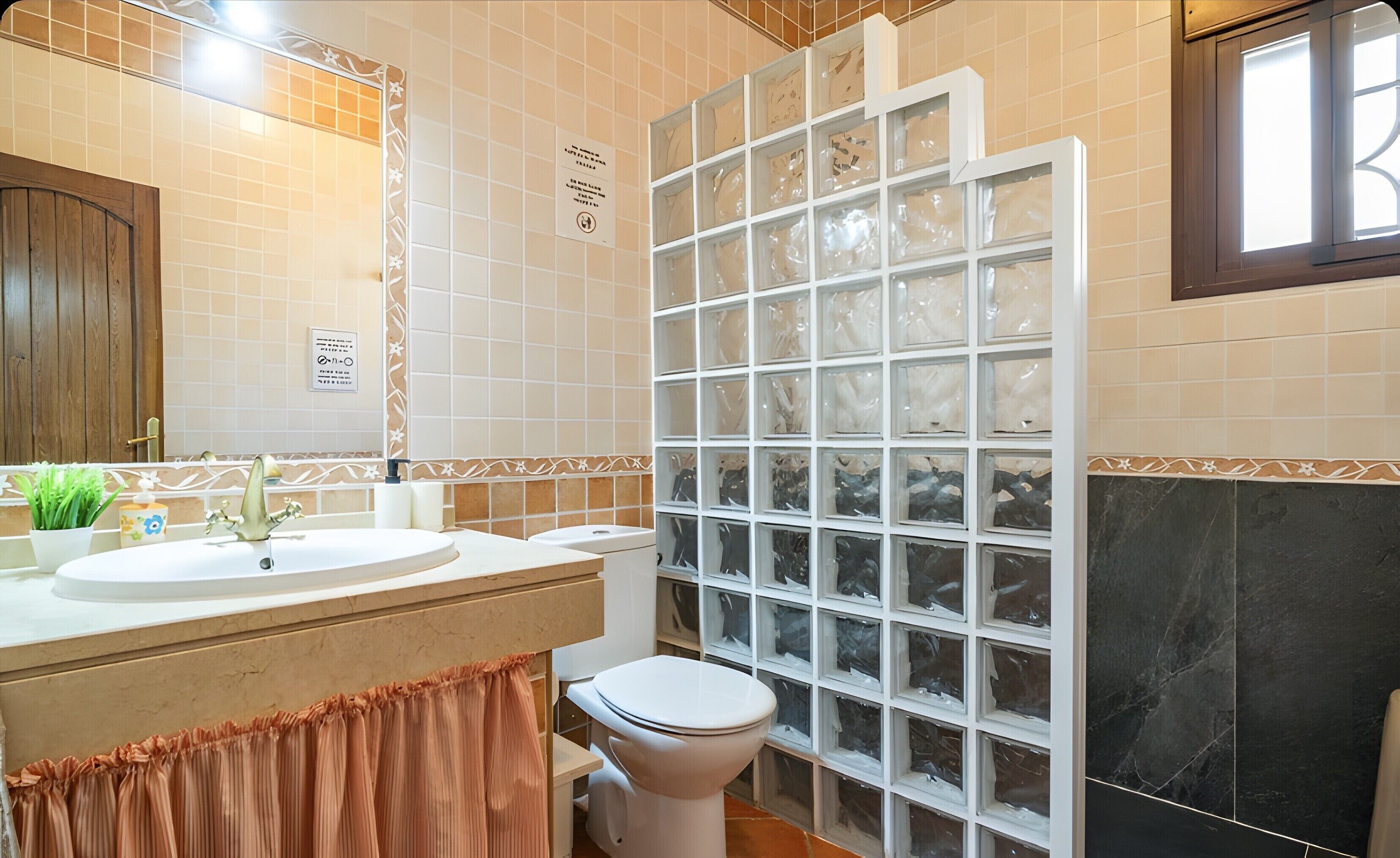 Un baño con lavamanos, inodoro y cabina de ducha.