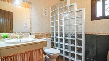 Un baño con lavamanos, inodoro y cabina de ducha.