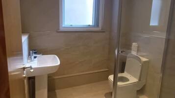 A bathroom with a sink, toilet, and shower.
