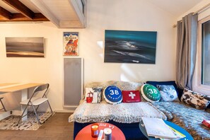 A room with a bed, a desk, and a chair. There are pillows with numbers and a flag on the bed.