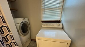 A laundry room with a washing machine, a dryer, and a stacked washer-dryer unit.