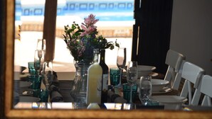 Ein Esstisch gedeckt mit Gläsern und einer Blumenarrangements.
